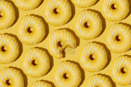 Foto de Rosquillas de limón en esmalte amarillo sobre un fondo amarillo. patrón. - Imagen libre de derechos