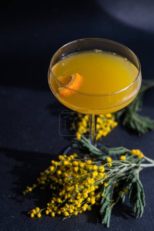 Téléchargez les photos : Mimosa cocktail in the glass on black stone table - en image libre de droit