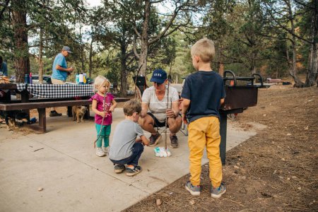 Photo for Grandma hands out marshmallows to kids while camping in Utah - Royalty Free Image