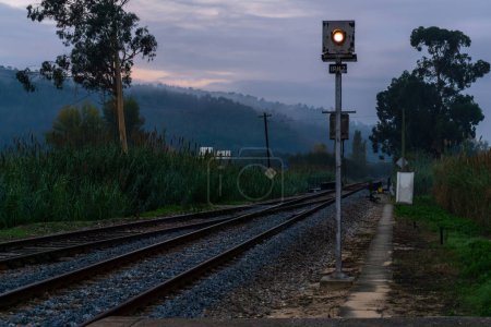 Téléchargez les photos : Paysage avec sémaphore ferroviaire et voies contre les collines dans le brouillard - en image libre de droit