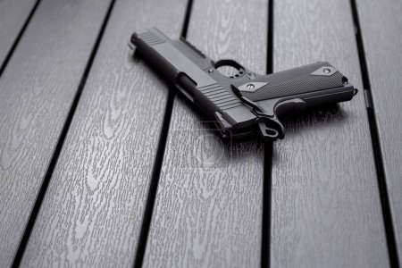 Foto de Classic airsoft gun placed on a dark wooden board. - Imagen libre de derechos