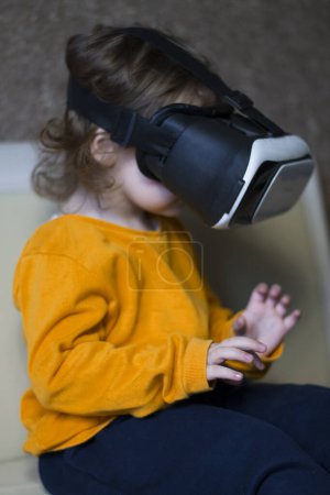 Téléchargez les photos : Petit enfant jouant à des jeux virtuels dans des lunettes vr - en image libre de droit