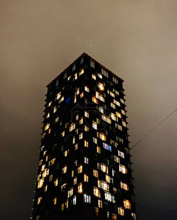 Téléchargez les photos : Building with many windows with lights seen from below at night - en image libre de droit