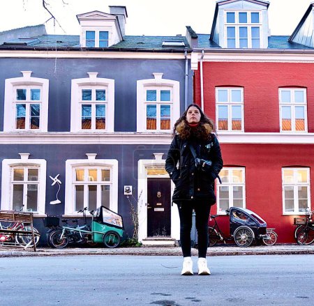 Téléchargez les photos : Femme marchant dans les rues de maisons colorées de copenhagen - en image libre de droit