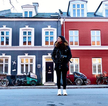 Téléchargez les photos : Femme marchant dans les rues de maisons colorées de copnhage - en image libre de droit
