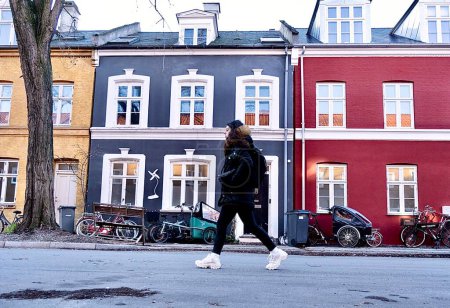 Téléchargez les photos : Femme marchant dans les rues de maisons colorées de copnhage - en image libre de droit