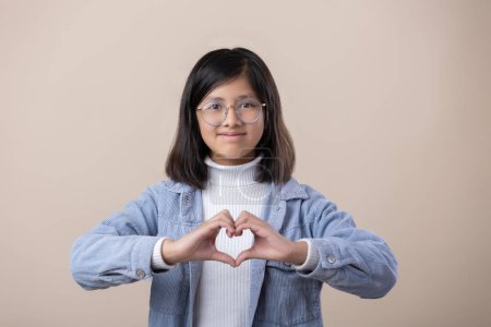 Photo for Mexican young girl making heart with hands, self love, women's rights - Royalty Free Image