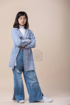 Photo for Full shot of Mexican young girl arms crossed serious face. blue jeans - Royalty Free Image