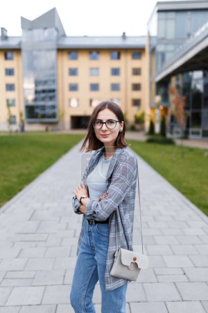 Téléchargez les photos : Young female student in a jacket and jeans on campus - en image libre de droit