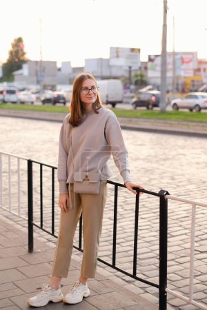 Foto de Portrait of a young woman in glasses walking through the evening city - Imagen libre de derechos