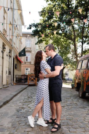 Téléchargez les photos : Man and woman romantically kissing on the city street in summer - en image libre de droit