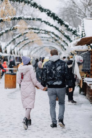 Téléchargez les photos : Couple amoureux se promène dans une ville enneigée d'hiver - en image libre de droit