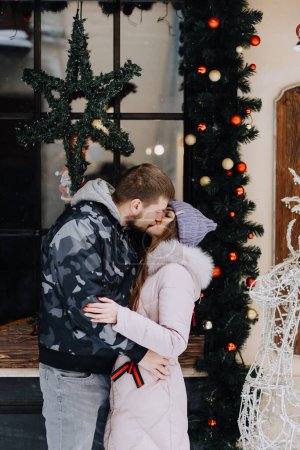 Photo for Couple in love is kissing in  snowy winter town - Royalty Free Image