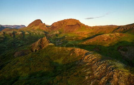 Téléchargez les photos : Paysage aérien pittoresque d'une chaîne de montagnes rocheuses sous le ciel bleu du coucher du soleil en Islande - en image libre de droit