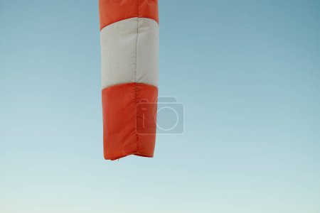 Photo for From below of striped windsock hanging against cloudless sky showing windless weather in Reykjavik - Royalty Free Image