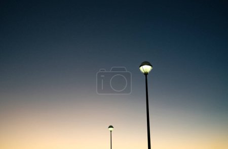 Téléchargez les photos : Low angle of tall streetlights on black poles against dark blue cloudless sky in Reykjavik - en image libre de droit