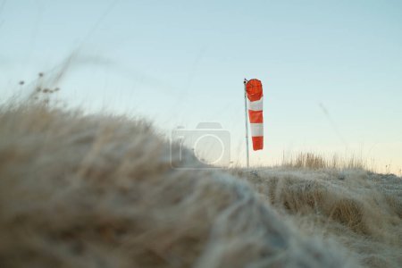 Photo for From below of wind sleeve with red and white stripes located on Reykjavik airfield in quiet weather - Royalty Free Image