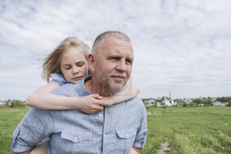 Photo for Daughter embracing father carrying her piggyback. - Royalty Free Image