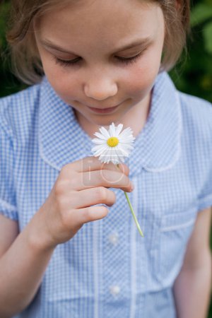 Téléchargez les photos : Portrait d'une fille avec une fleur de marguerite. - en image libre de droit
