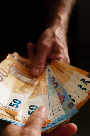 Foto de Man handing euro banknotes to woman - Imagen libre de derechos