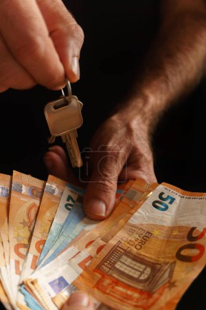 Foto de Mujer entregando dinero y hombre entregando las llaves de una casa - Imagen libre de derechos