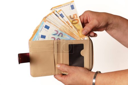 Téléchargez les photos : Femme sortant des billets en euros de son portefeuille - en image libre de droit