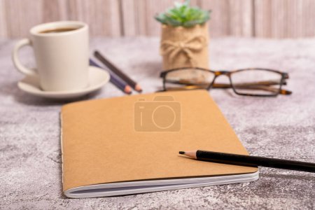 Téléchargez les photos : Closed notebook with brown covers, pencil, glasses and coffee cup with copy space - en image libre de droit