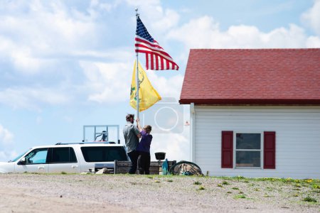 Téléchargez les photos : Père et fils portant un drapeau américain sur le mât.. - en image libre de droit