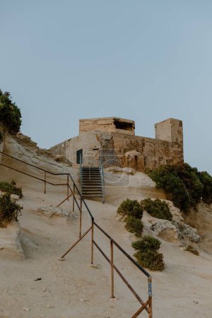 Téléchargez les photos : Coucher de soleil d'été nager sur une plage locale à Malte pendant l'heure bleue - en image libre de droit