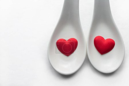 Téléchargez les photos : Red Heart shapes in white spoons with copy space for text and design - en image libre de droit