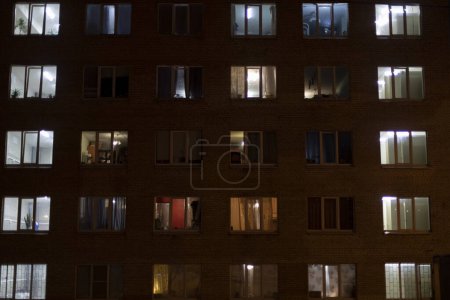 Téléchargez les photos : Fenêtres dans la maison la nuit. Lumière des fenêtres des appartements. - en image libre de droit