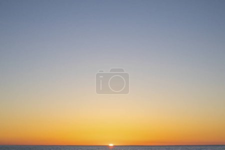 Photo for Orange sun setting over lake - Royalty Free Image