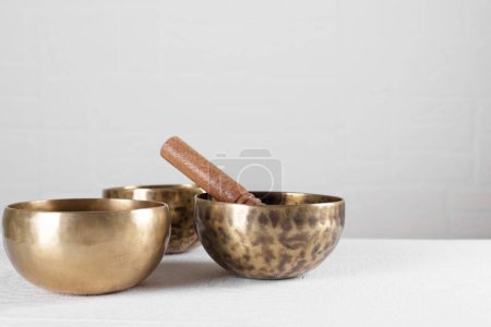 Photo for Tibetan singing bowls with sticks on white wall background - Royalty Free Image