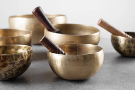 Tibetan singing bowls with sticks for mantra meditations on grey stone