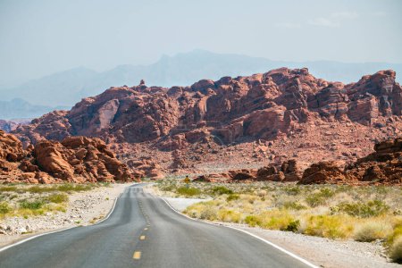Téléchargez les photos : Winding road in the desert with reddish mountains in the bkgrnd - en image libre de droit