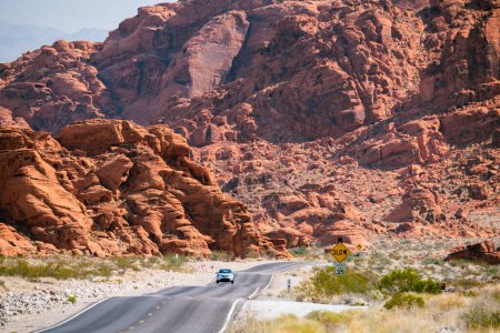 Téléchargez les photos : Route sinueuse dans le désert avec des montagnes rougeâtres dans le bkgrnd - en image libre de droit