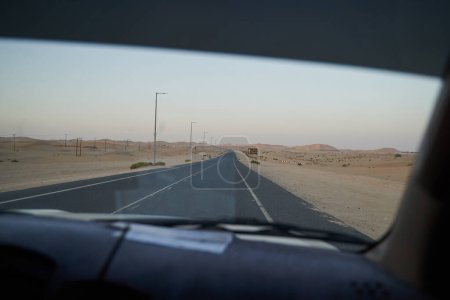 Foto de View from the car window on a paved road in the middle of the desert. - Imagen libre de derechos