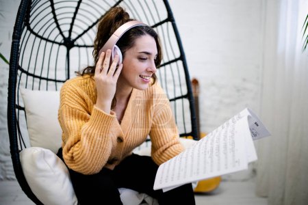 Téléchargez les photos : Young Woman with headphones composing music at home - en image libre de droit