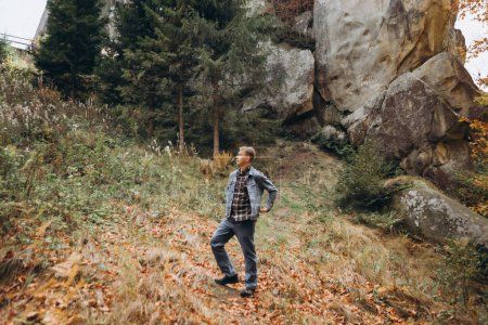 Foto de Hombre camina por el bosque cerca de las montañas - Imagen libre de derechos