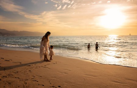 Téléchargez les photos : Mère et fille tenant la main sur la plage - en image libre de droit