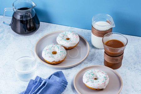 Photo for Donuts in white glaze with colored sprinkles - Royalty Free Image