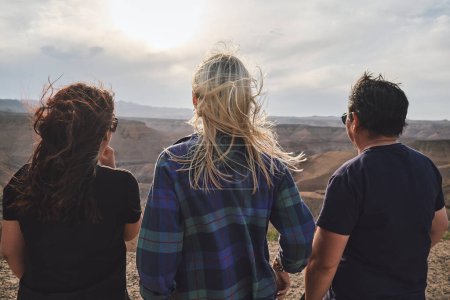 Téléchargez les photos : Trois personnes regardant le Grand Canyon d'un point de vue, venteux - en image libre de droit