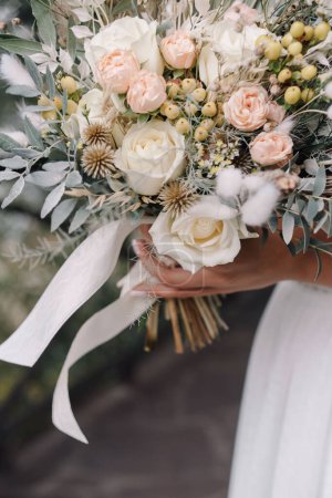 Téléchargez les photos : Mariée dans une robe de mariée tenant un bouquet de mariage - en image libre de droit