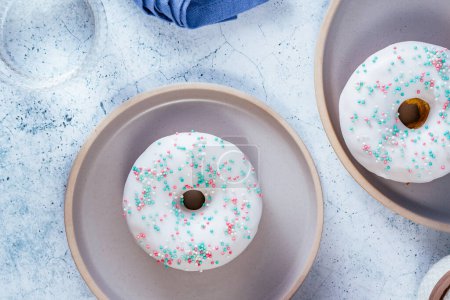 Téléchargez les photos : Donuts en glaçure blanche avec des arrosages colorés - en image libre de droit