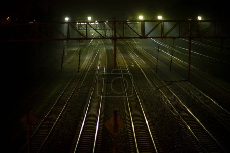 Foto de Ferrocarril por la noche. Carriles en la estación. Muchas vías para trenes. Sistema de transporte. - Imagen libre de derechos