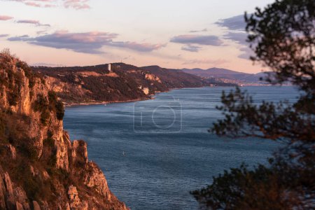 Photo for Golden sunset at the sea with rocky coastline, view to Trieste gulf - Royalty Free Image