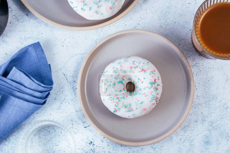 Photo for Donuts in white glaze with colored sprinkles - Royalty Free Image