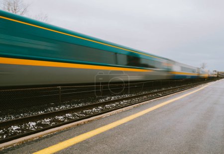 Foto de Tren de pasajeros en movimiento rápido borroso que viaja por las vías. - Imagen libre de derechos