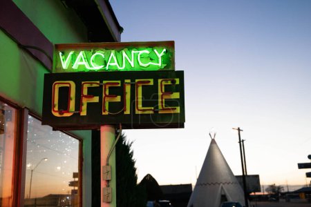 Téléchargez les photos : Glowing neon vacancy sign at the wigwam motel office at sunset - en image libre de droit