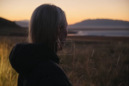 Téléchargez les photos : Portrait de femme blonde cherchant à lever du soleil sur un lac Tuz Kol - en image libre de droit